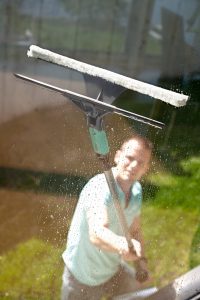 Mann vasker vindu utvendig med forlengerskaft