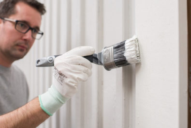 Illustrasjonsbilde av mann som maler huset