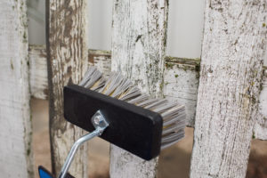 Vasker gjerdet med kraftvask før maling