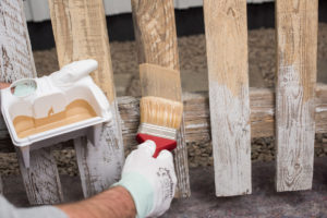 Påføring av grunning på gjerdet før maling