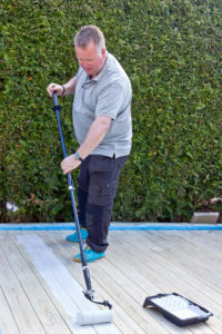 Mann oljer terrasse med forlengerskaft