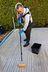 Mann påfører rensemiddel med malerull